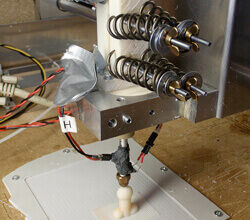 A 3D printer creates a small dildo.