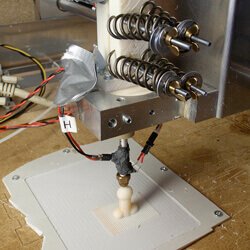 A 3D printer creates a small dildo.
