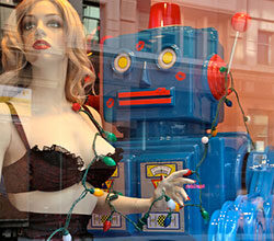 A robot and an artificial woman stand close.