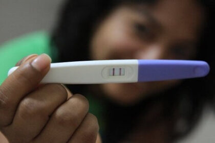 A lady holding a pregnancy test
