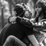 A passionate couple sit at the park.