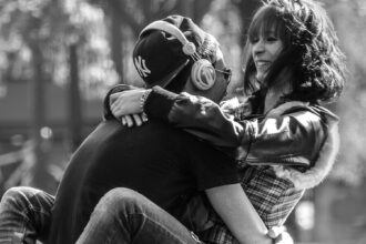A passionate couple sit at the park.