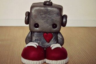 A sad little robot standing on the floor.