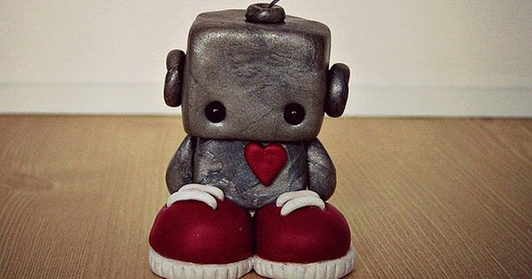 A sad little robot standing on the floor.