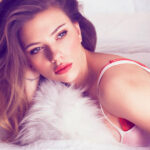 A photo of actress Scarlett Johansson posing on a bed.