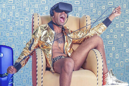 A good-looking young man sits and wears a VR headset.