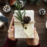 Male hands hold a wrapped present.