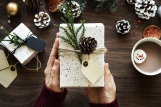 Male hands hold a wrapped present.
