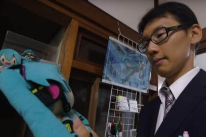 Japanese man holds a stuffed animal versions of his hologram wife.