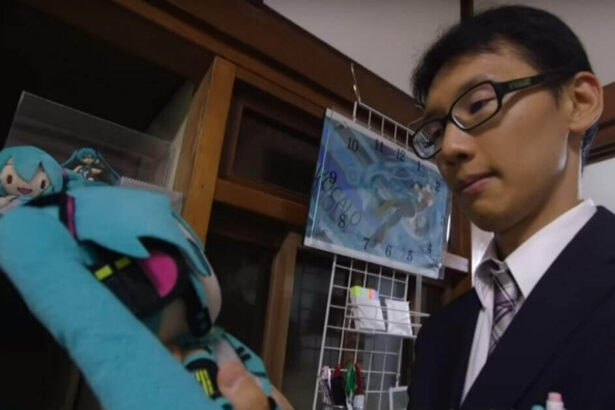 Japanese man holds a stuffed animal versions of his hologram wife.