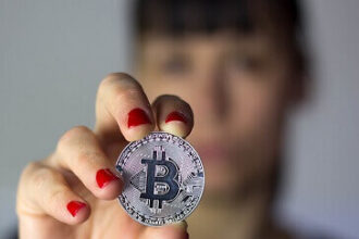 Girl holding silver Bitcoin