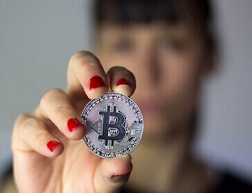 Girl holding silver Bitcoin