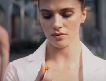 Woman looking at pill in Brave New World TV Show.