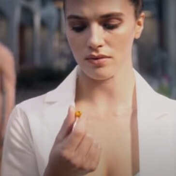 Woman looking at pill in Brave New World TV Show.
