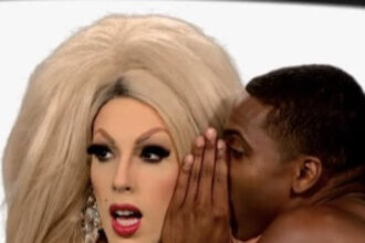 A drag queen appears shocked as a black man whispers in their ear.