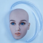 Kokeshis face and head, without hair, appears in a bath of white fluid.