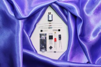 A purpe satin sheet encircles disassembled electronic parts.