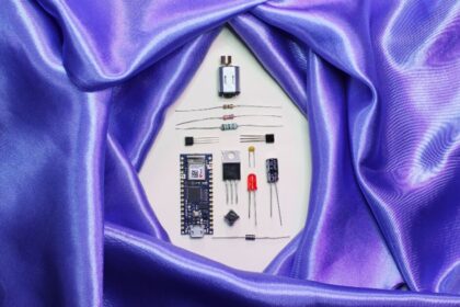 A purpe satin sheet encircles disassembled electronic parts.