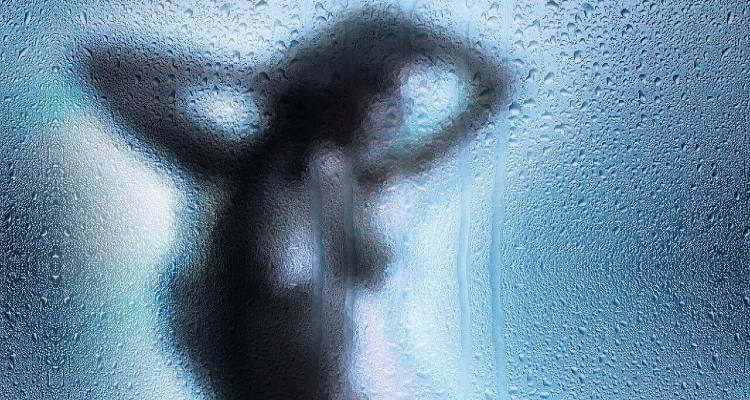 Screenshot of a women taking bath beyond a shower screen