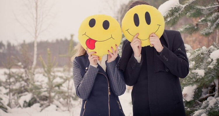 Image of Couple Holding Smiley over their Face in Cold Winter