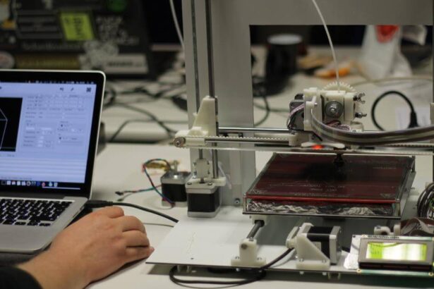 Image of a man working on laptop and 3D printer