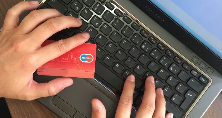 Hands with credit card on computer keyboard