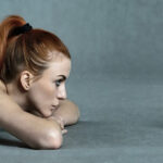 Image of a naked beautiful girl lying before old camera for selfie