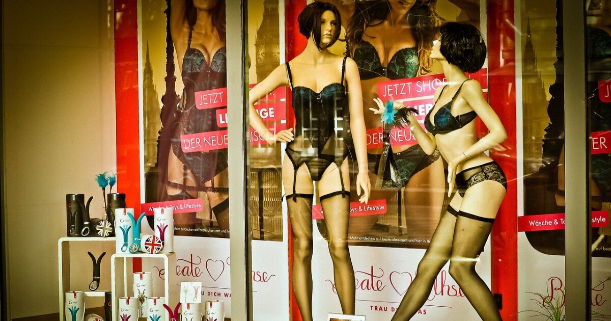 2 mannequin in lingerie displaying sex toys in window shopping area of a store