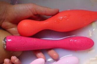 Image of a women in bath tub with sex toys in her hand