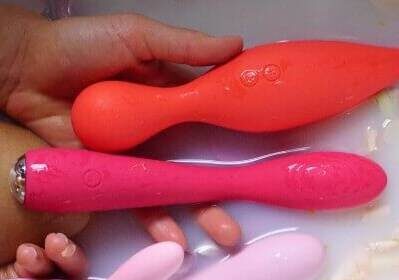Image of a women in bath tub with sex toys in her hand
