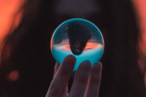 The silhouette of a person with long hair holding a crystal ball.