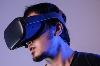 Man wearing vr head gear and haptic controllers.