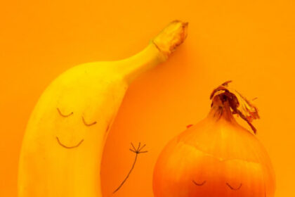 banana and onion sleeping in bed with faces drawn on them