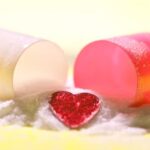 A heart gem comes out of an opened pill casing.