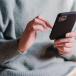 Stock image of a person scrolling through a phone.