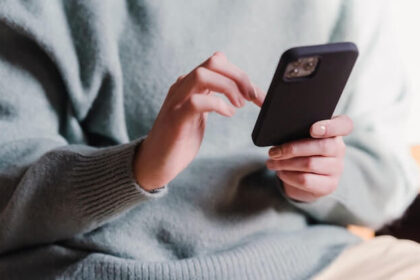 Stock image of a person scrolling through a phone.