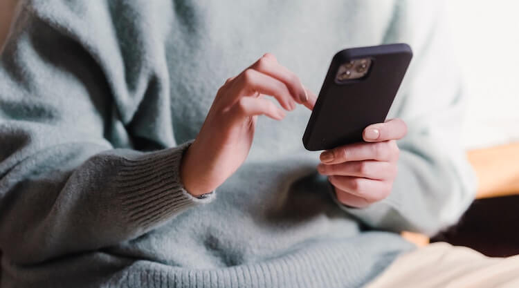 Stock image of a person scrolling through a phone.