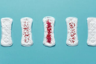 Five menstrual pads with varying degrees of red sprinkles on top to represent the various stages of periods.