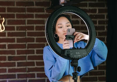 An influencer setting up her phone and ring light.