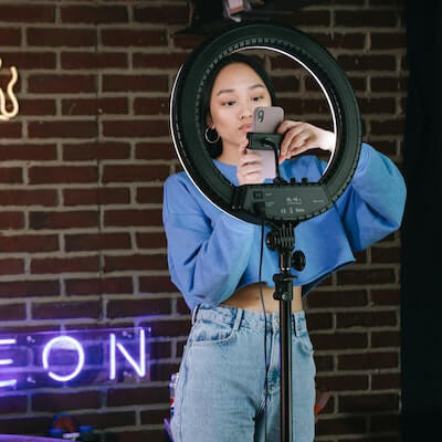 An influencer setting up her phone and ring light.