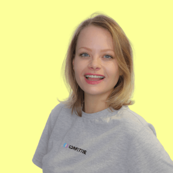 Konfettie's founder and CEO Emilie Wiersma. She is smiling with light skin, a grey t-shirt and a longer blonde bob.
