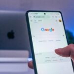 A phone lit up against a dark background, showing the Google search console.