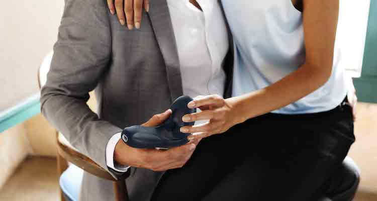A couple with a woman sitting on a man's lap. They each are holding the Tenuto 2 with one hand.