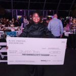 Glenise holding a check for $250,000.
