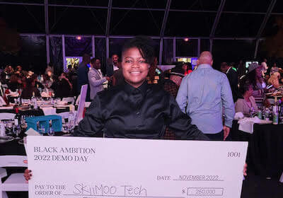 Glenise holding a check for $250,000.