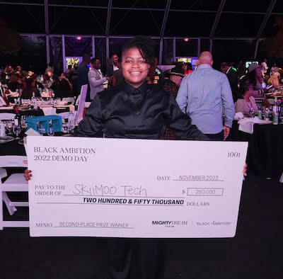 Glenise holding a check for $250,000.