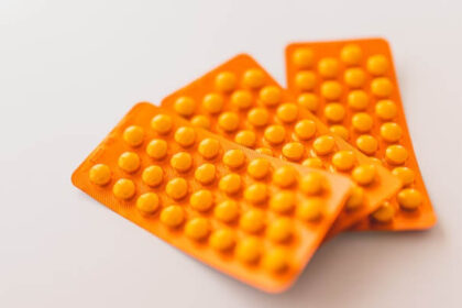 Orange packages of medications on table.