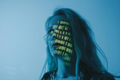 Woman in blue lighting with yellow binary code projected across her face.